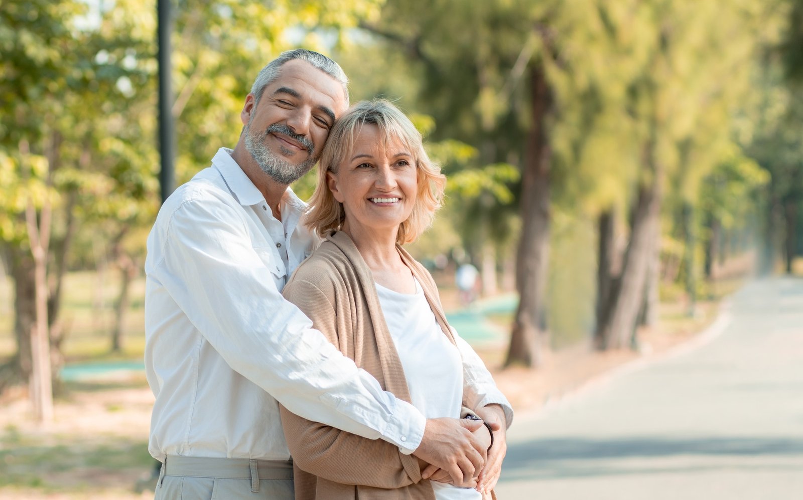 Happy elder love couple huge and smiling in romance in park