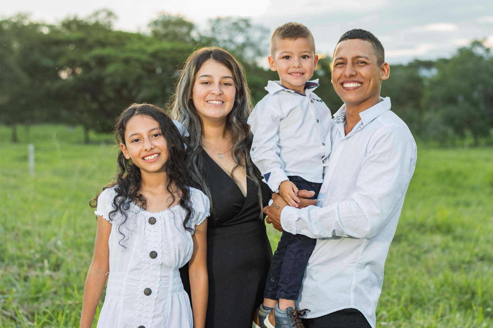 Colombian family, smiling very happy, daughter, mother, father and son posing in the countryside.