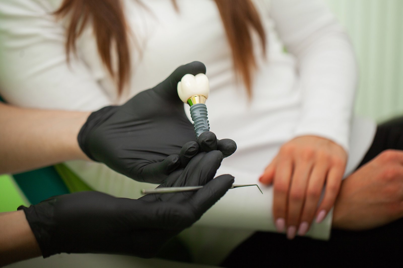 Dentist explaining teeth model to female patient. Technical shots on a dental prothetic laboratory