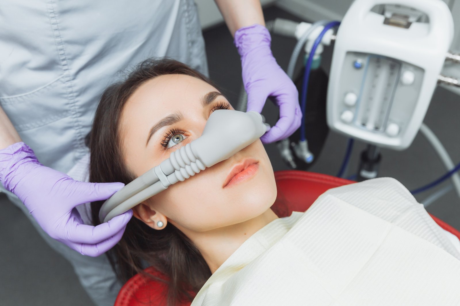 dentist puts inhalation sedative mask on his patient.