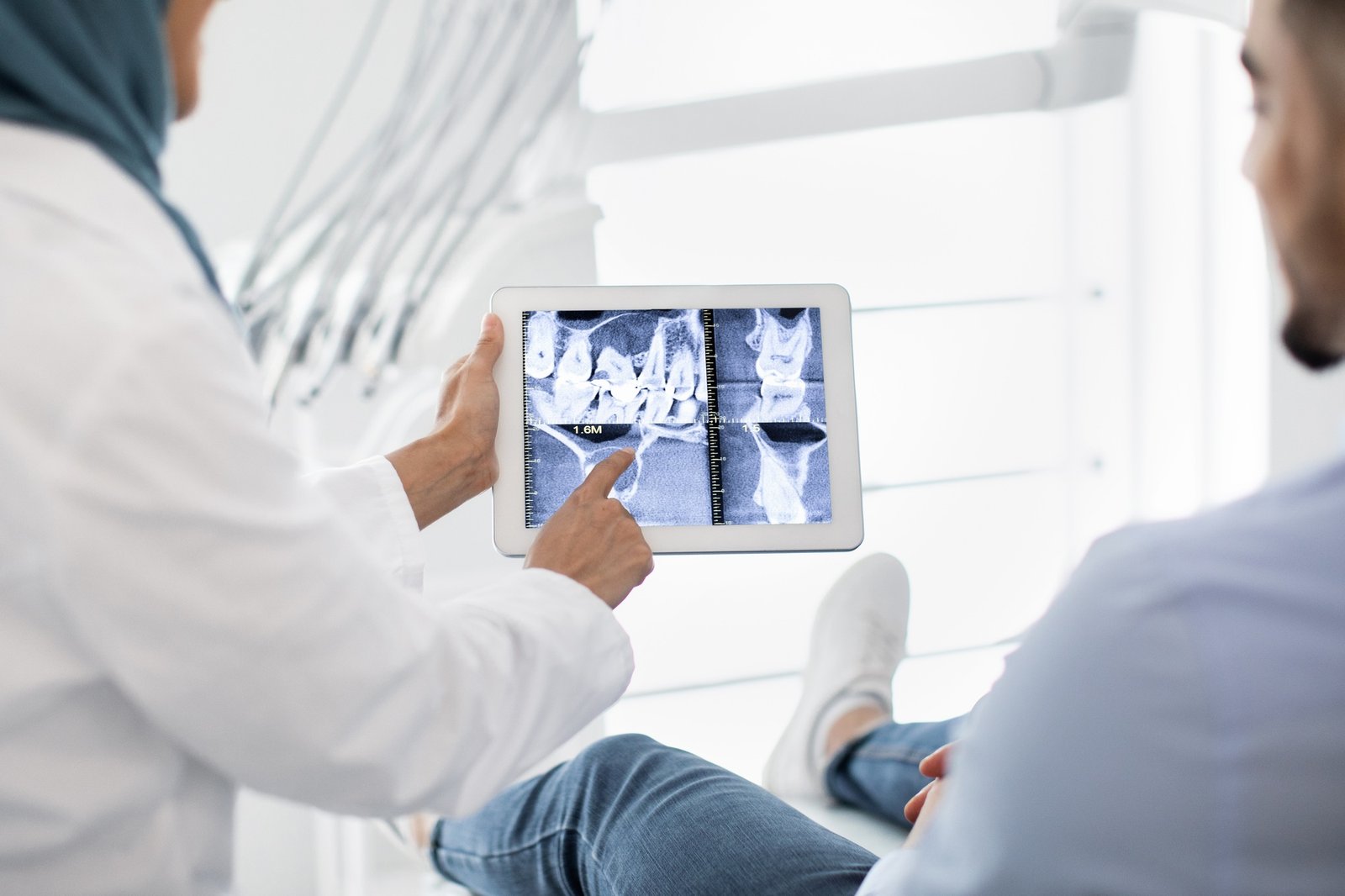 Oral Surgery. Female Dentist In Hijab Demonstrating Teeth Xray On Digital Tablet