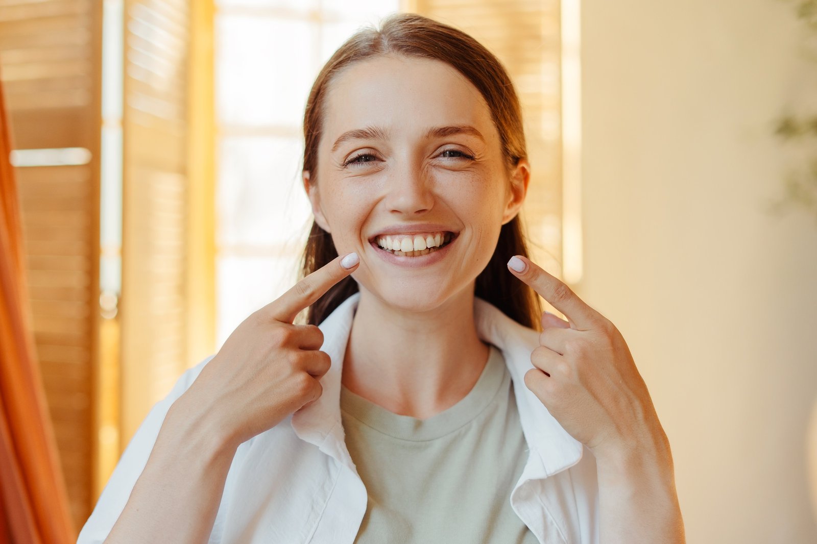 Woman showing her perfect smile pointing fingers at teeth